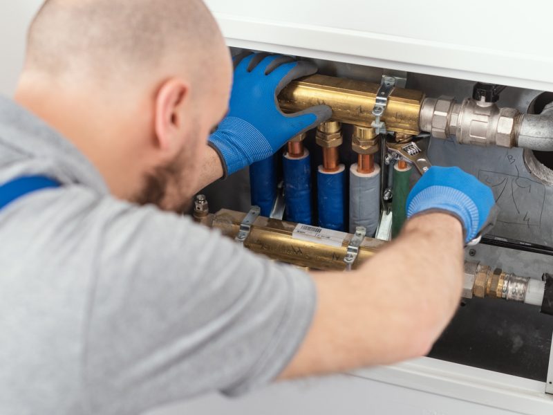 Professional plumber installing plumbing manifolds Professional plumber installing plumbing manifolds